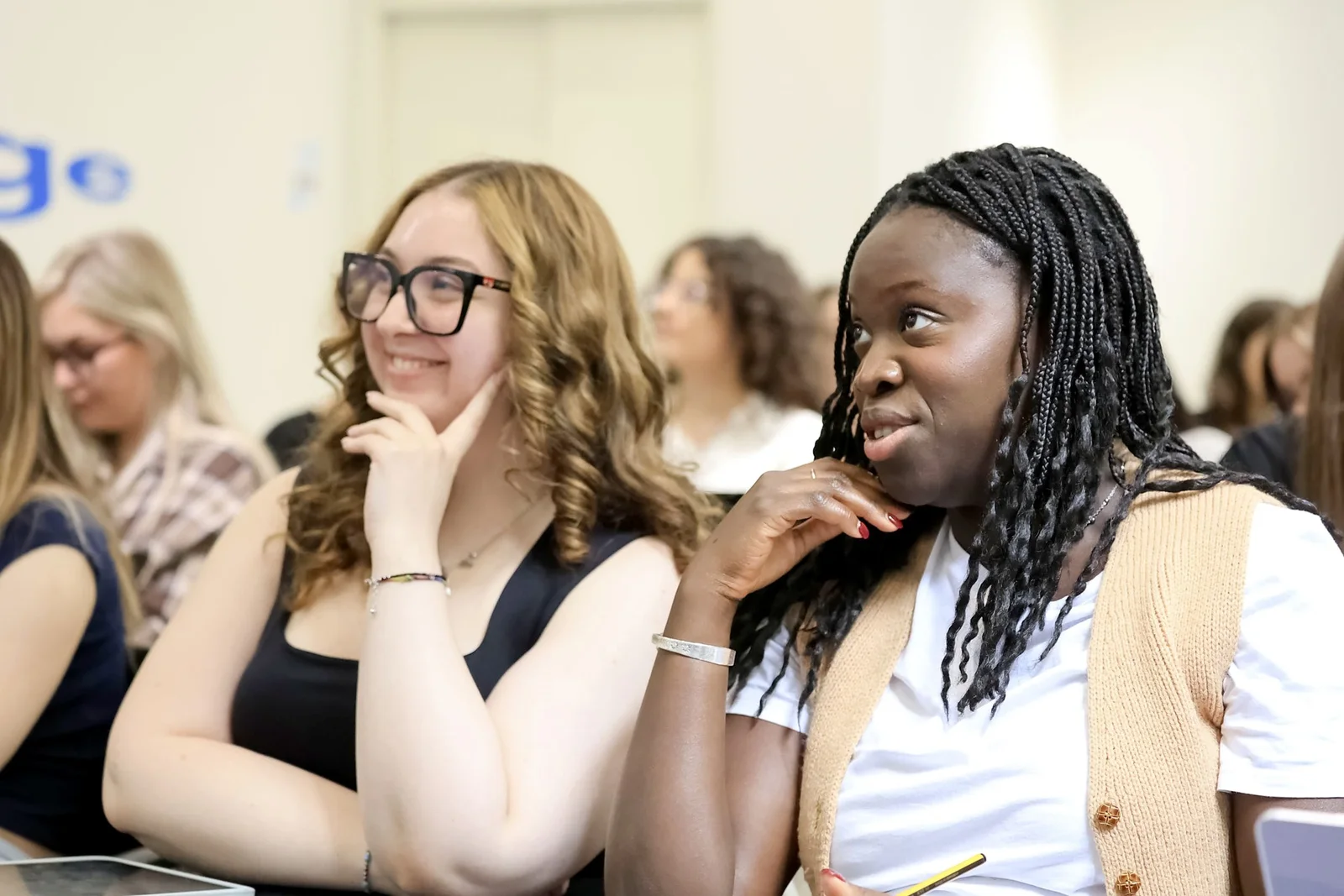 Two pre-health students smiling and listening during a university lecture